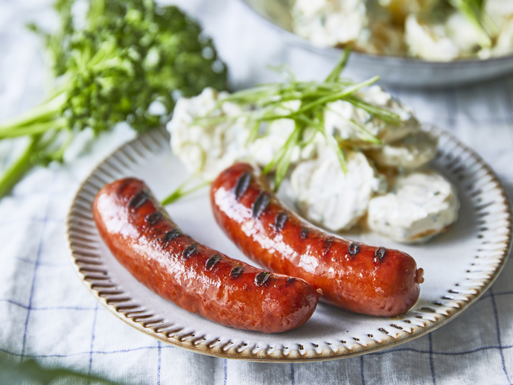 En tallerken med lækre grillede kålpølser og med en klassisk kartoffelsalat til